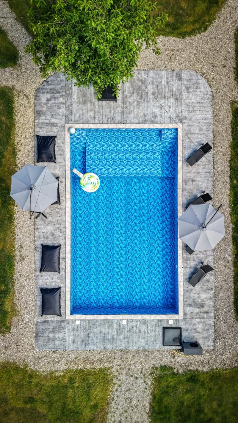 Piscina văzută de sus, cu șezlonguri și umbrele